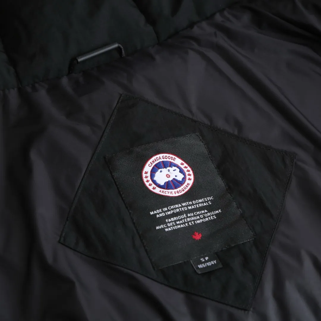 P1010 [Exclusive supply] Canada Goose Black Label Badge Hooded Down Jacket (Black) The high-quality filling is made of 90 national standard high-quality white duck down, selected high-loft velvet, weighing 240g, light and warm, with excellent temperature locking performance and good resilience. The fabric is woven with 400T high-count yarn. After special water-repellent treatment, the surface forms a lotus leaf effect - raindrops will slide down like beads, and snow particles will fall off when touched. The tear resistance reaches 200N (approximately 20kg load-bearing), the light gray matte texture breaks the stereotype of "outdoor clothing = hardcore", and the soft luster presents a high-end matte effect under urban neon lights, seamlessly switching scenes from ski resorts to CBD office buildings. The ribbon is woven with polyester as the base, and the brand letters are decorated on the ribbon through high-precision computer embroidery. The edges of the pattern are clear, the stitches are fine and even, and multiple layers of embroidery thread are stacked to enhance the three-dimensional effect. Precision thread reinforcement prevents linting and ensures the fluffy and resilient elasticity lasts as new. The embedded cuffs are three-dimensionally woven to form a "wavy" elastic structure, which forms natural folds when fitting the wrist, increasing the contact area with the skin, thus improving the windproof effect. At the same time, micro-velvet treatment is added to the inside of the cuffs, which feels like a second layer of skin and avoids friction on the skin from metal zippers or hard fabrics. Size:S-M-L-XL